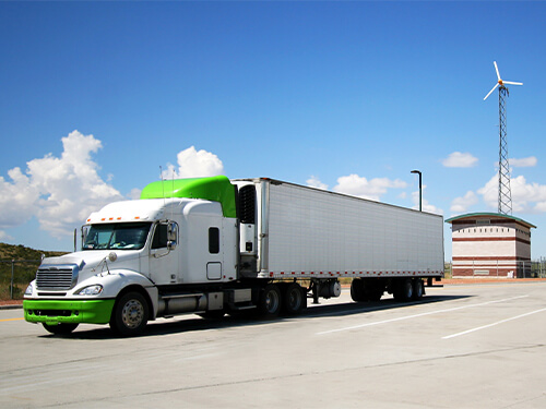 Green semi-truck driving on a road